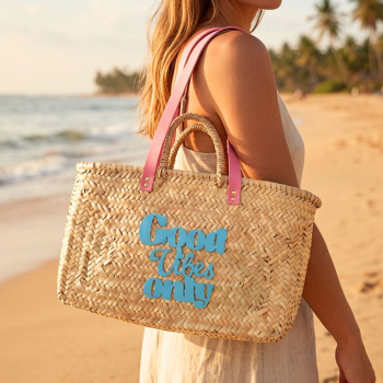 Rectangular palm leaf beach basket with bubblegum pink leather handles and turquoise hand-sewn motif