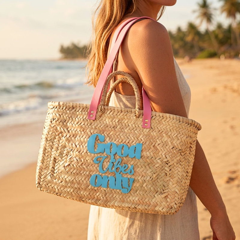 Rectangular palm leaf beach basket with bubblegum pink leather handles and turquoise hand-sewn motif