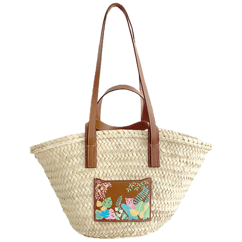 pink leopard straw basket worn on the shoulder with leather handles
