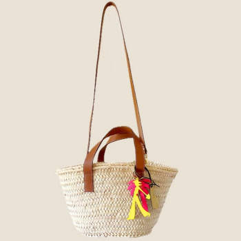 Mini handwoven palm leaf basket carried by hand with leather handles