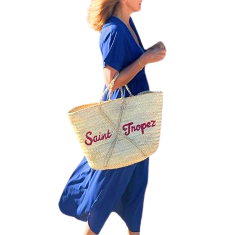 Red hand-painted Saint-Tropez lettering on handmade straw basket
